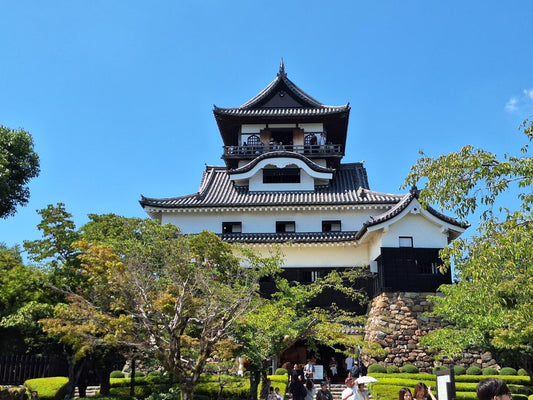 Inuyama Castle above trees under a clear blue sky