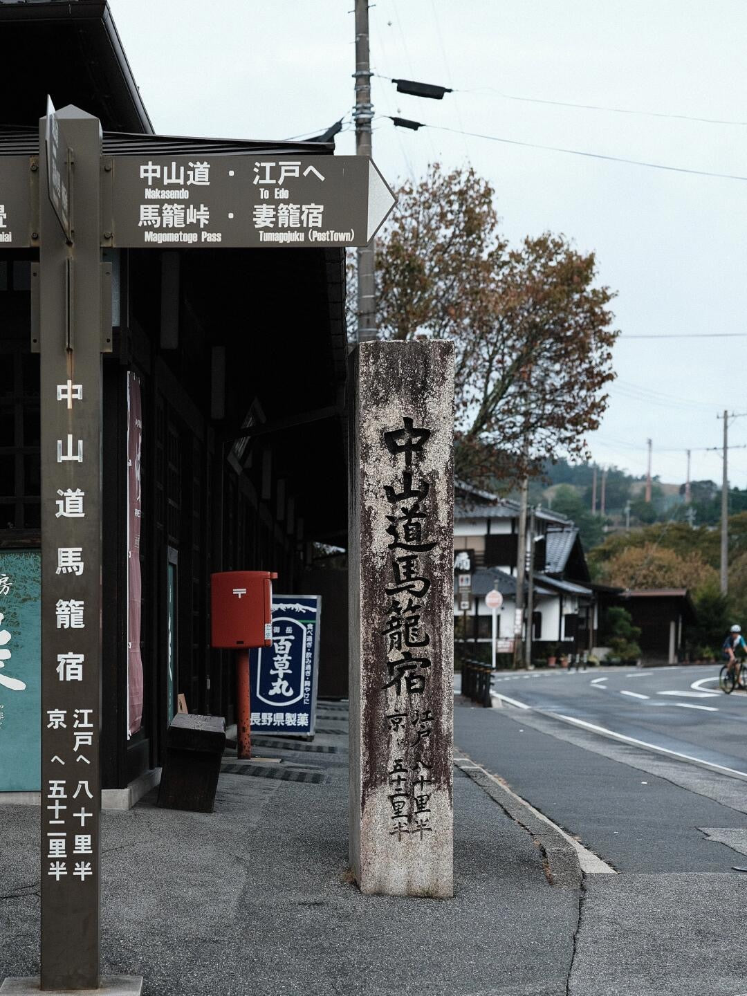 Nakasendo trail sign beside historic post town buildings