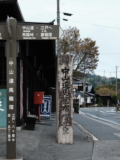 Nakasendo trail sign beside historic post town buildings